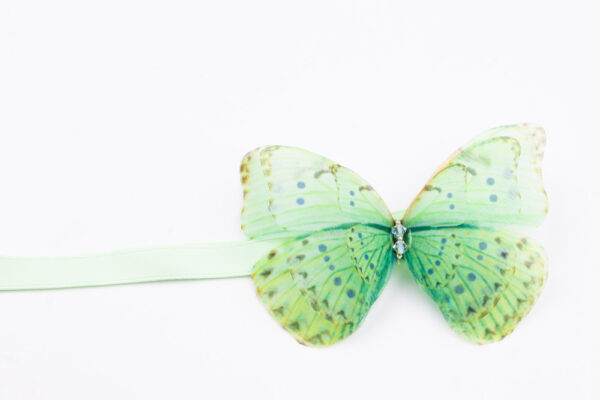 This handmade ribbon tie accessory is meticulously crafted with precision, capturing the likeness of a real butterfly. A versatile accessory that can be worn in mustiple ways. Whether styled around your neck as a choker necklace or worn adorning the hair, it fastens with a silk ribbon tie, making the fit fully customizable.